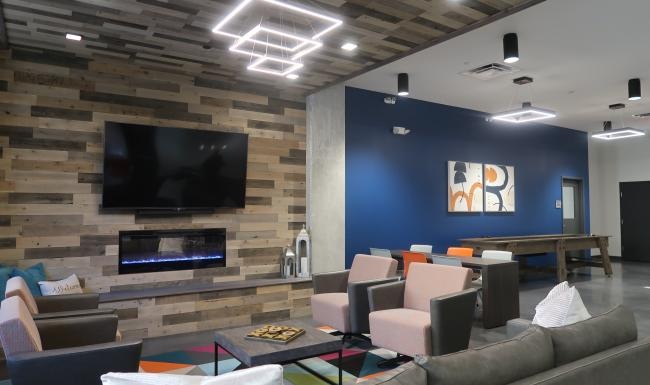a clubroom with a tv, chairs and tables